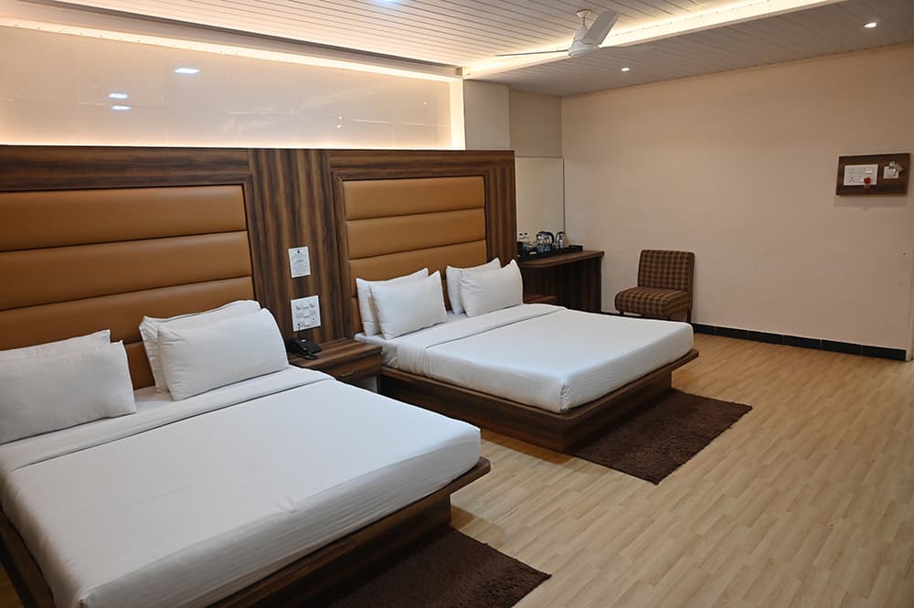 Premium family room with two beds, an armchair and a tea desk